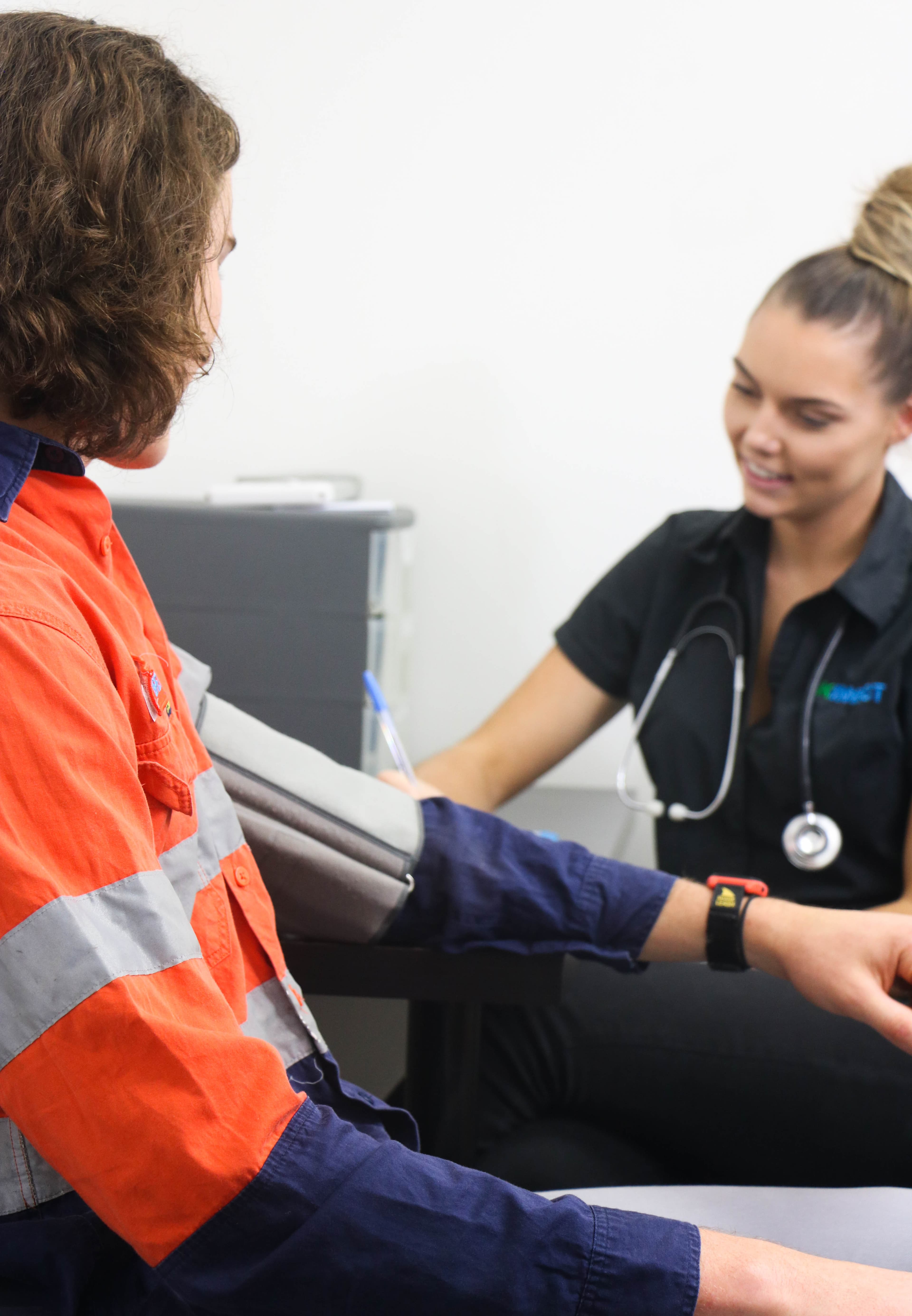 KINNECT clinician taking a high-vis worker's blood pressure during a doctor-supervised health monitoring assessment