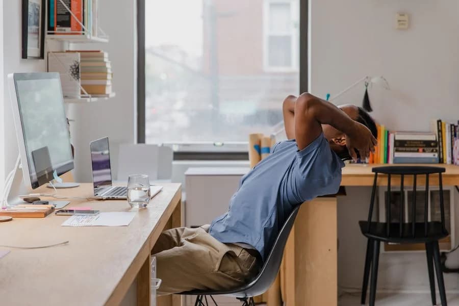 Office worker taking a seated stretch break — illustrative stock photograph, not a KINNECT SmartStretch session