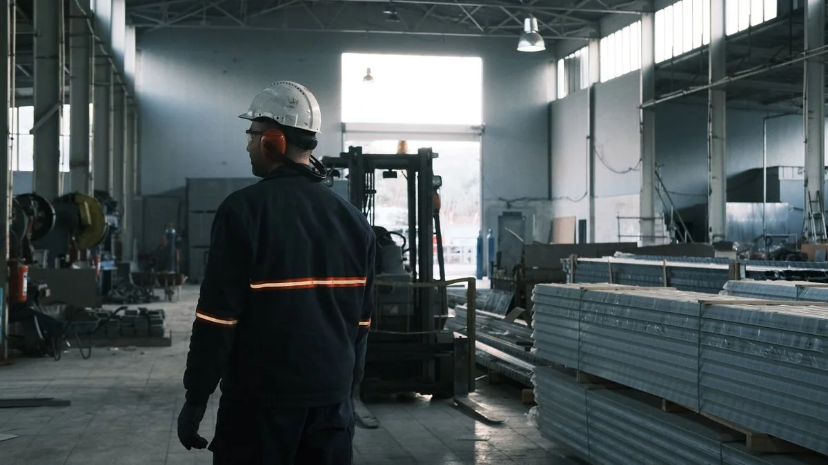 Worker wearing protective clothing inside an industrial workplace — illustrative stock photograph, not a KINNECT facility