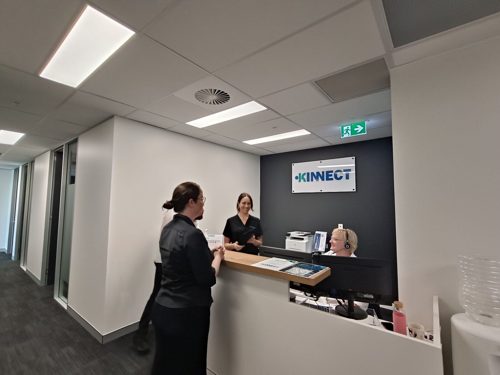 KINNECT clinic reception with Client Specialists greeting a colleague at the front desk