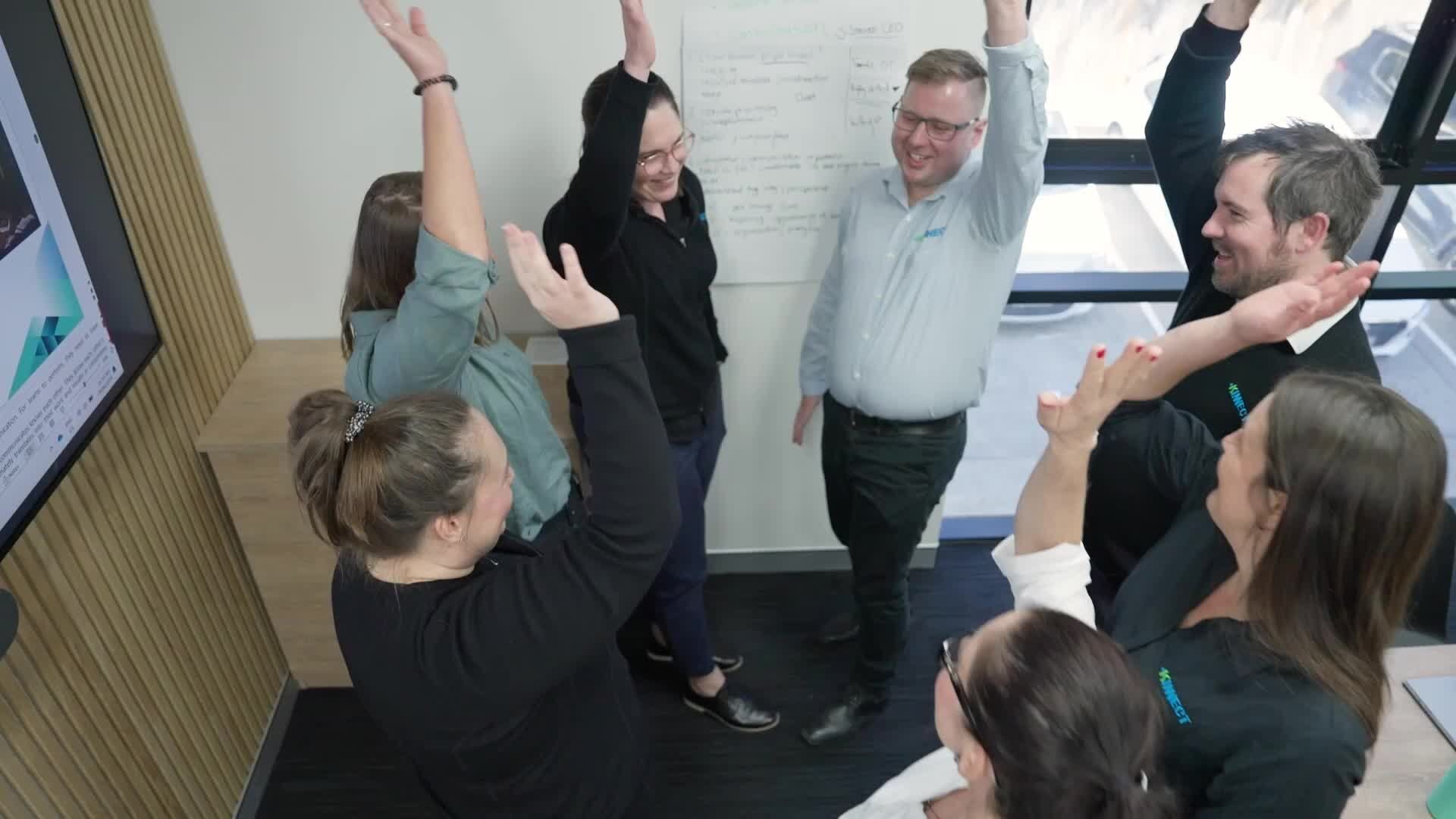 KINNECT team in a strategy workshop celebrating together with raised hands